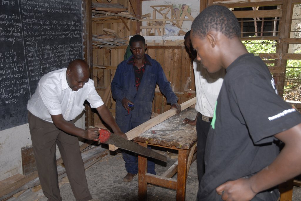 Visit to the carpenters' training program of the Kenya Evangelical Lutheran Church (KELC). The vocational trainer is wearing a white shirt.